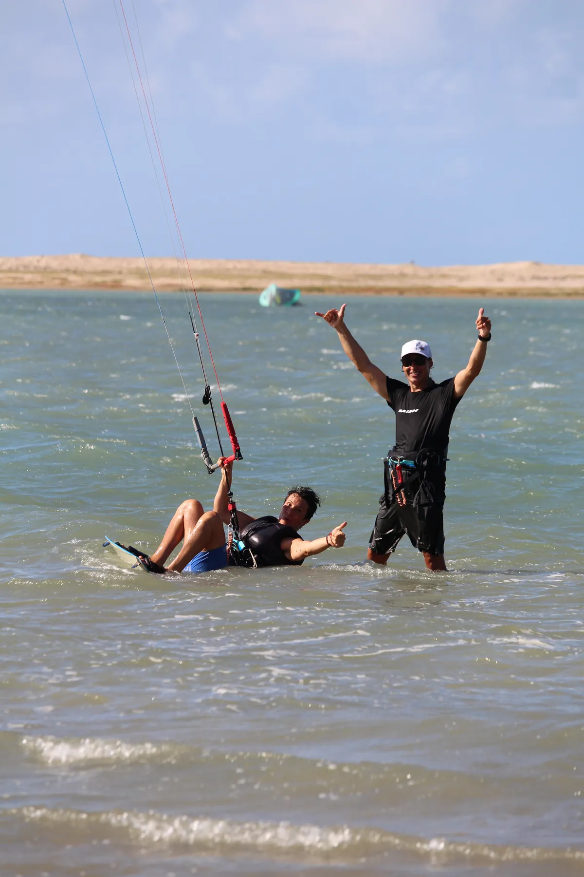 Instrutor ajudando aluno iniciante na água da Ilha do Guajirú