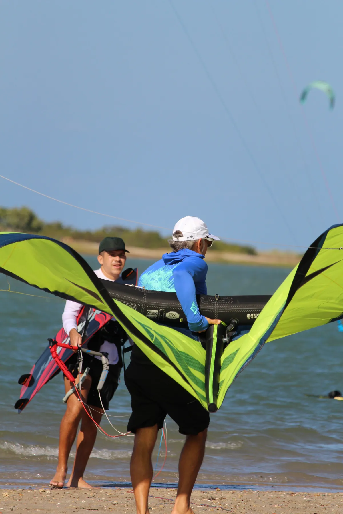 Equipe da Isla Kite Center auxiliando com o kite na praia da Ilha do Guajirú