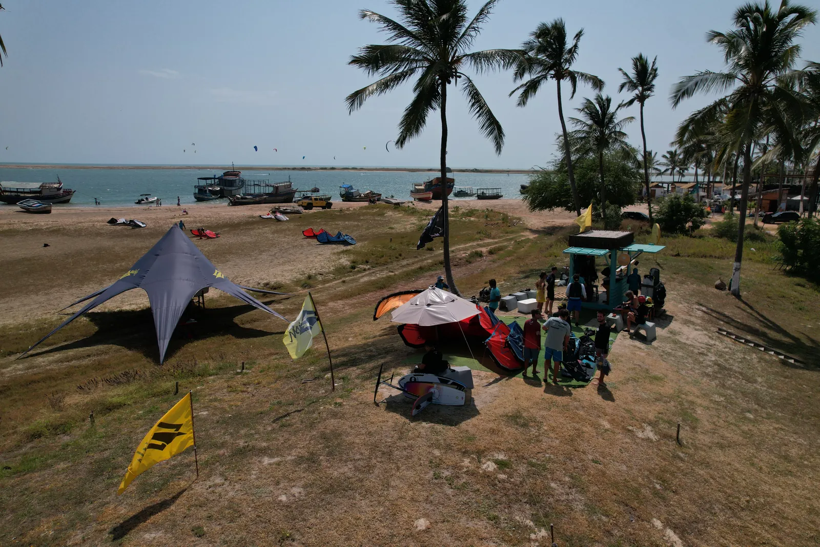 Área de acesso ao braço de mar da Ilha do Guajirú com equipamentos de kitesurf e coqueiros