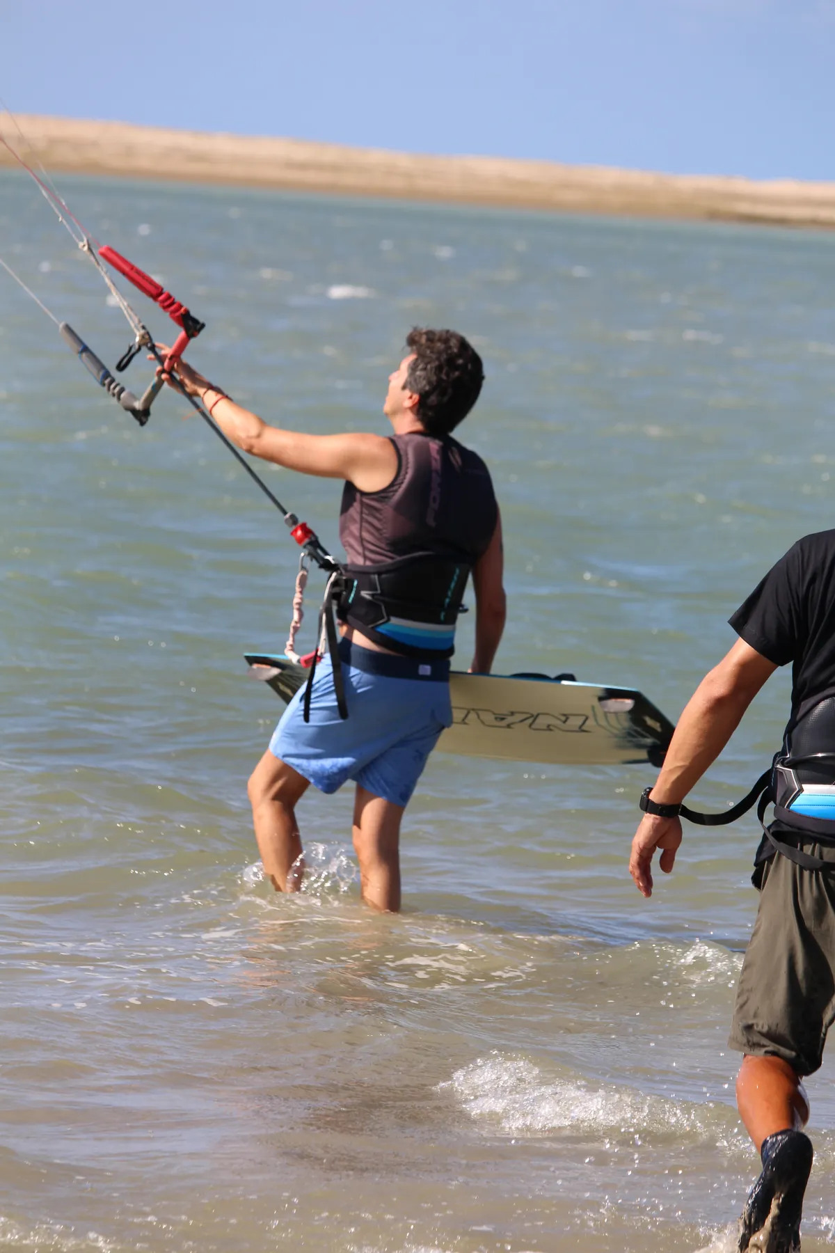 Instrutor da Isla Kite Center ensinando aluno iniciante na água rasa do braço de mar da Ilha do Guajirú
