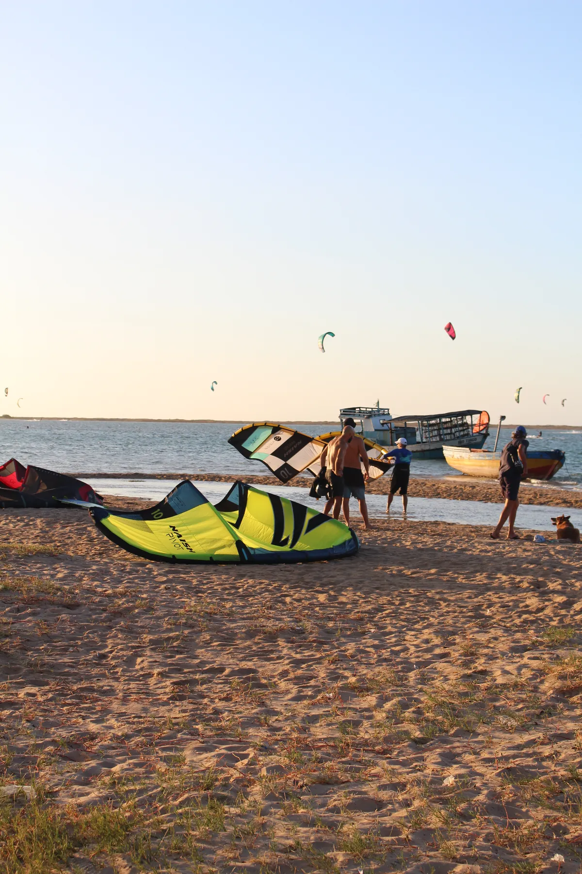 Fim de tarde na praia da Ilha do Guajirú com equipamento de kitesurf, jangada e coqueiros