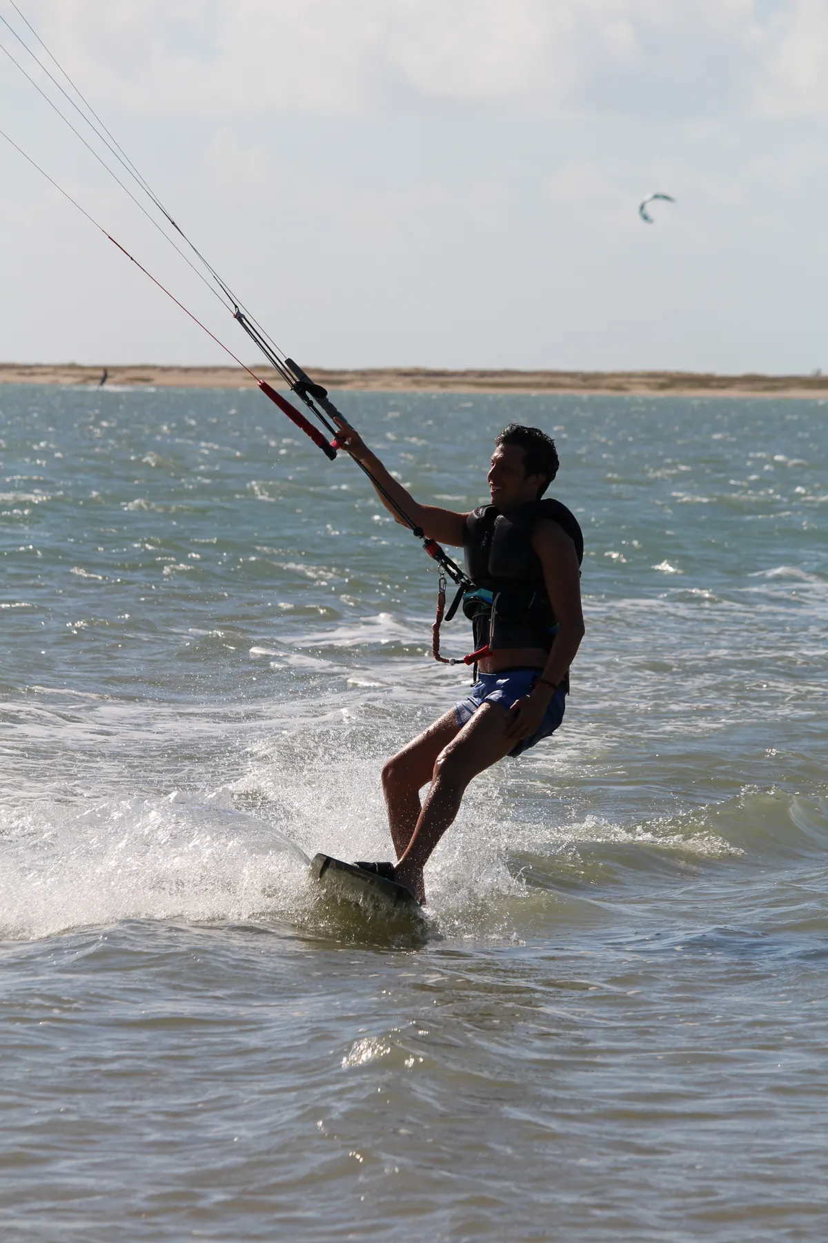 Kitesurfista velejando com vento de alísio na água plana da Ilha do Guajirú